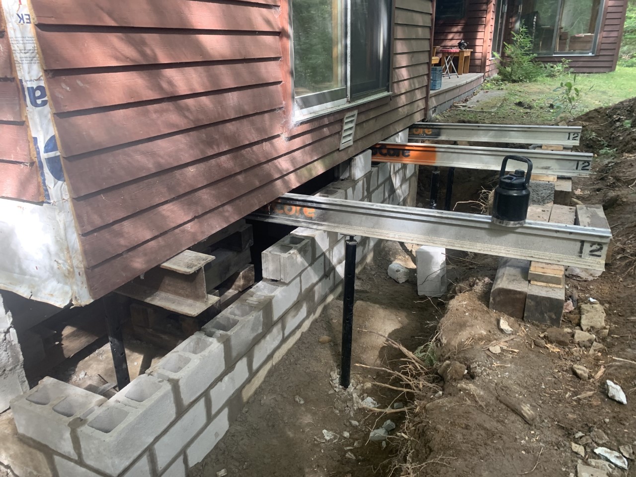 Home foundation undergoing repair with steel beams and cinder blocks providing structural support, illustrating one of the four common foundation problems and repair services available in Ottawa, Gatineau, or Kingston.