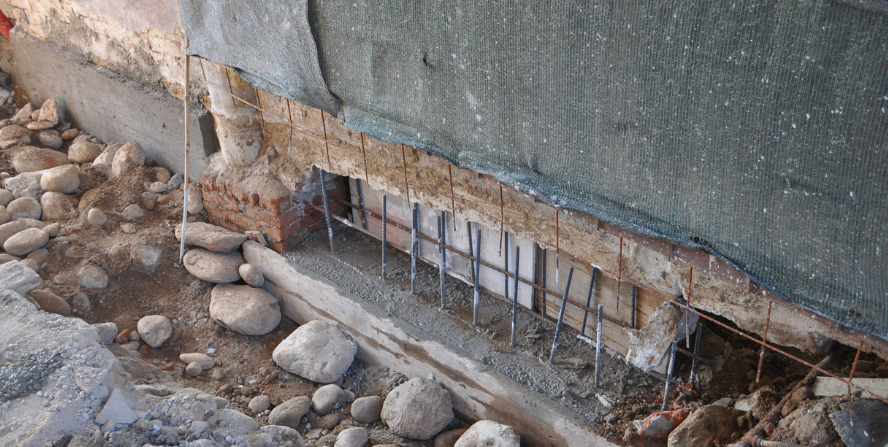 Basement underpinning process showing exposed foundation with reinforcement rods, illustrating structural support techniques used in Ottawa, Kingston, and Gatineau for reinforcing foundation stability.