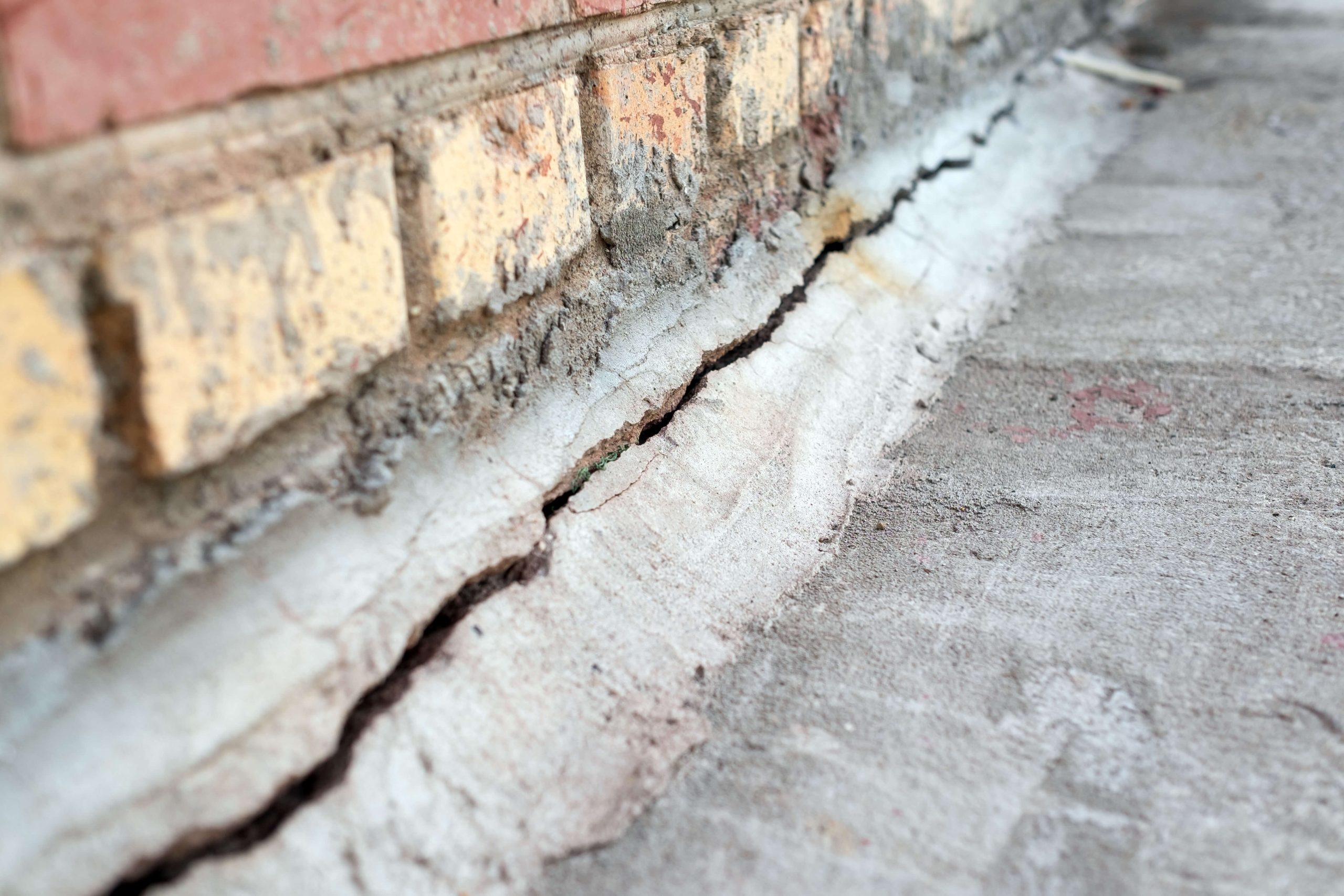 Crack in foundation requiring wall crack repair, visible cracks in foundation of a house.